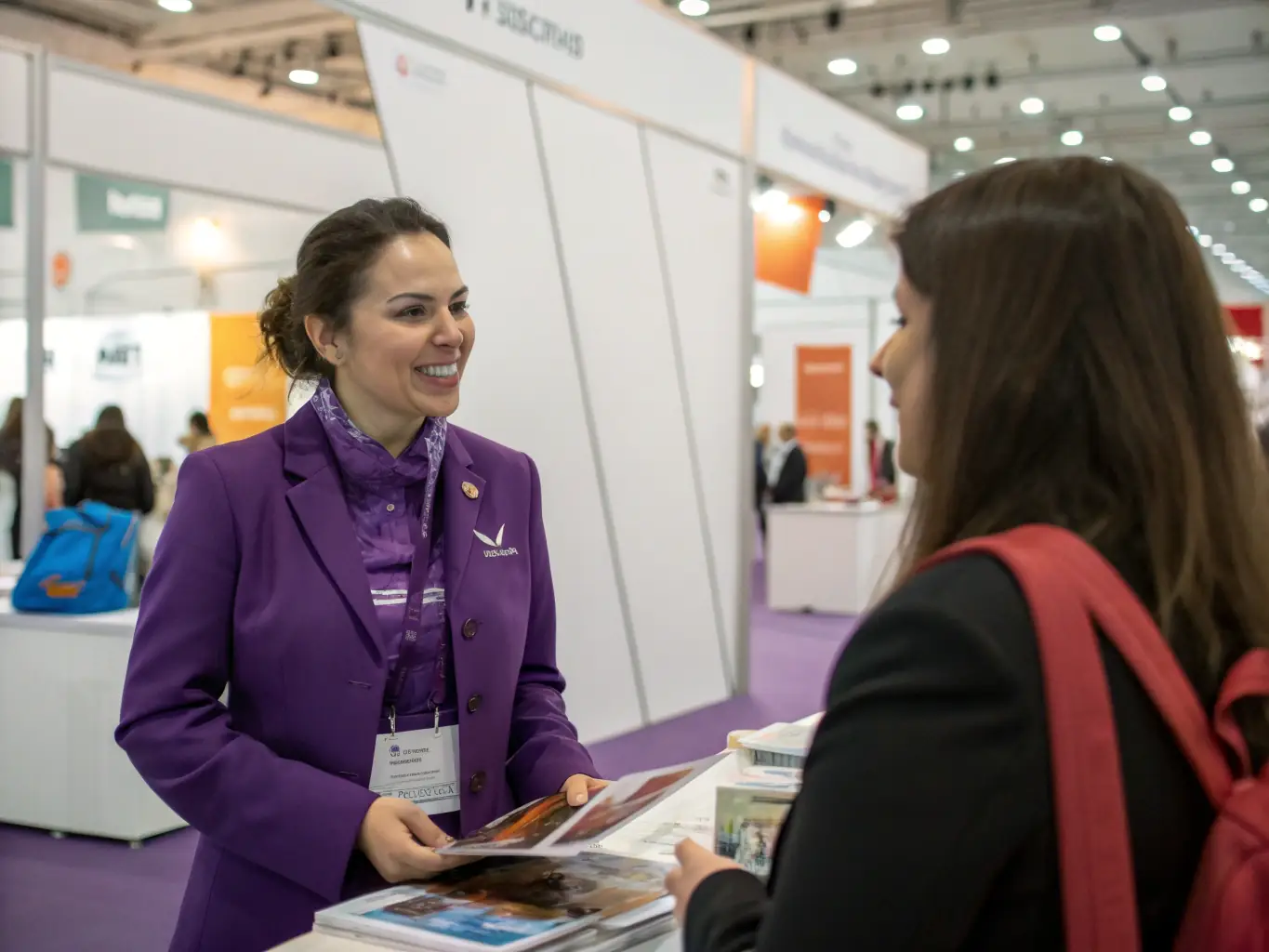 A photograph showcasing a promoter from Iconiq Agency interacting positively with attendees at a trade fair booth, demonstrating excellent communication skills and brand knowledge.